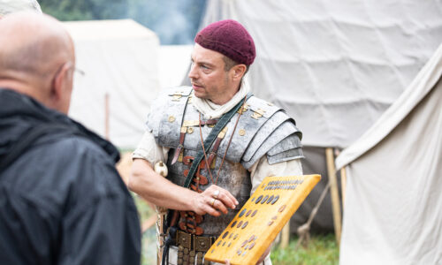 Roemerfest Augusta Raurica Legionaer zeigt eine Auswahl roemischer Muenzen Foto Matthias Willi
